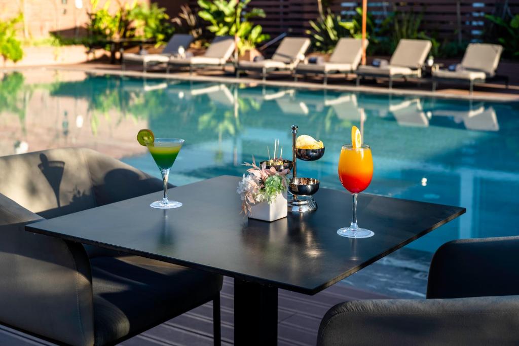 a table with drinks on it next to a swimming pool at Barceló Anfa Casablanca in Casablanca