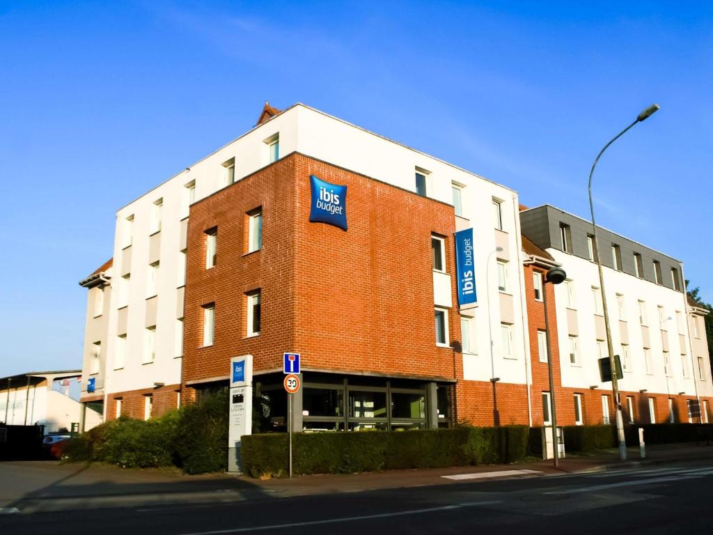 a large brick building on the corner of a street at ibis budget Saint-Omer Centre in Saint-Omer