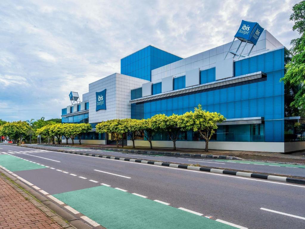 a blue building with a road in front of it at Ibis Budget Jakarta Menteng in Jakarta