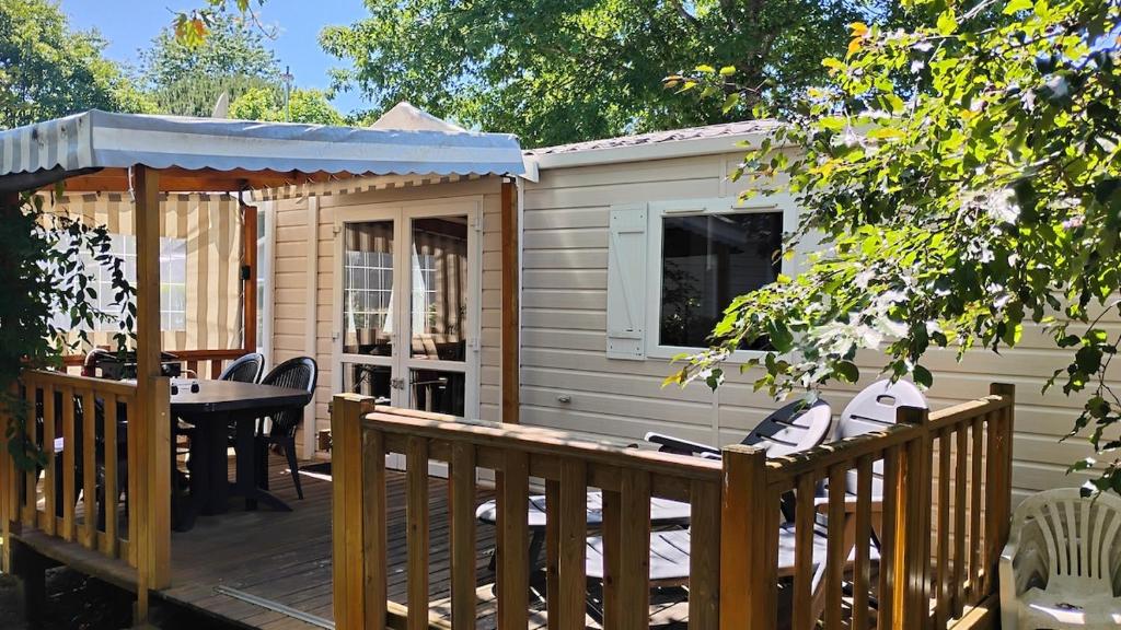 a deck with a table and a gazebo at Mobilhome 713 panoramique Siblu in Gastes