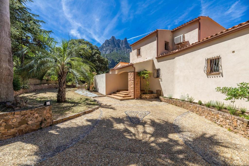 an exterior view of a house with mountains in the background at Villa Excelsior in Porto Ota
