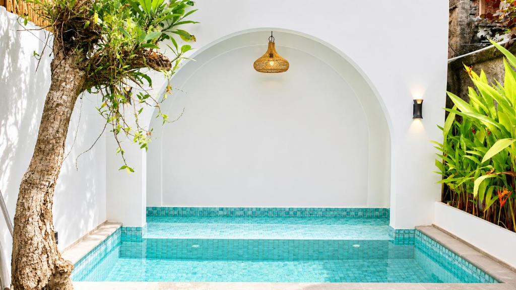 a swimming pool in a villa with a tree at Baliem Boutique Hotel Ungasan in Jimbaran