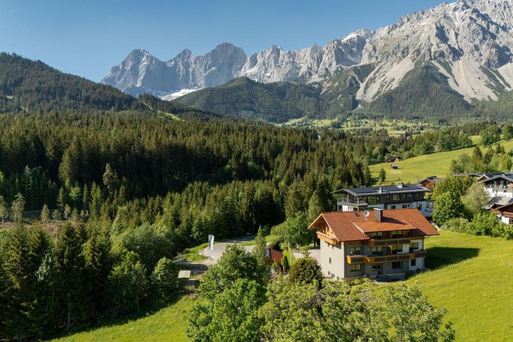 a house on a hill with mountains in the background at Bergvilla-Ramsau in Ramsau am Dachstein