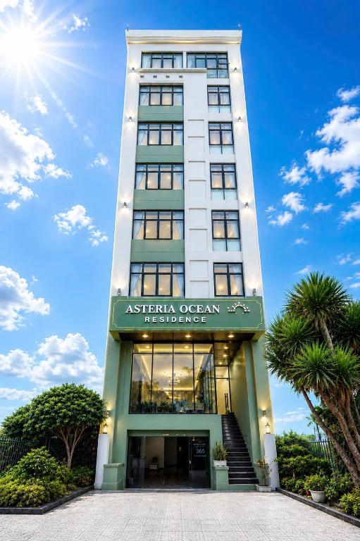 a tall white building with a sign on it at Asteria Ocean Residence in Danang