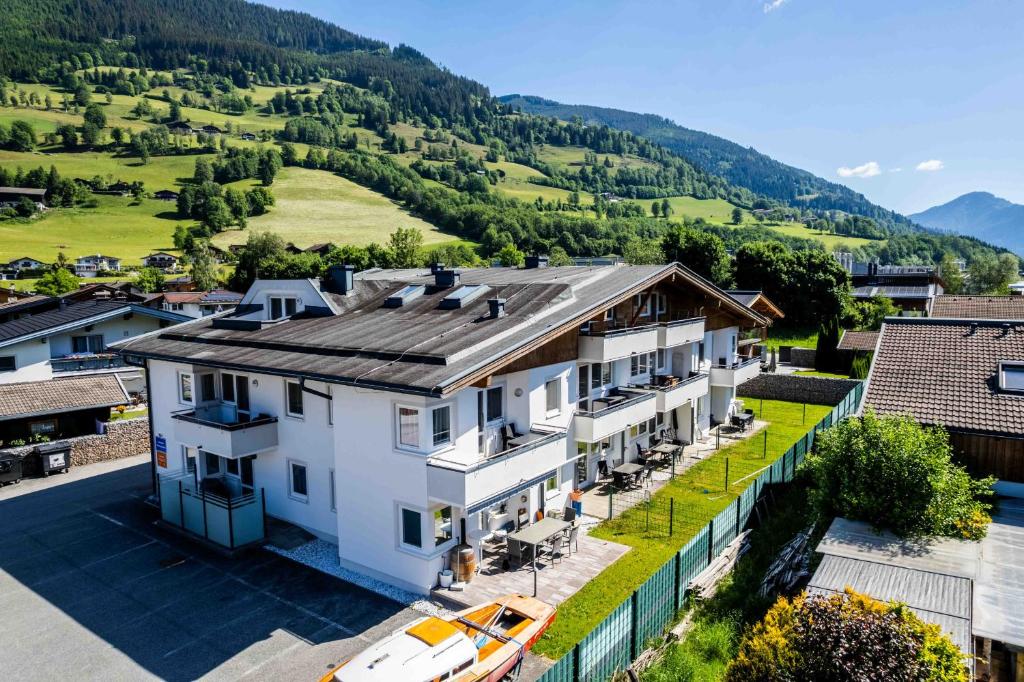 an aerial view of a white house with mountains in the background at Maiskogelblick Apartments by we rent in Piesendorf