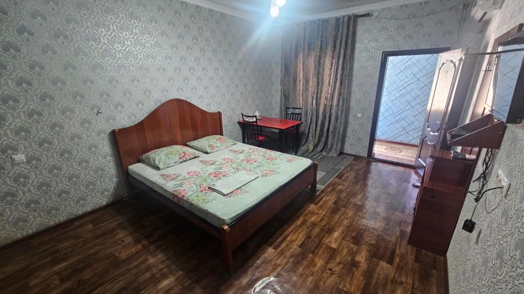 a small bedroom with a bed and a window at Гостиница Саян in Shymkent
