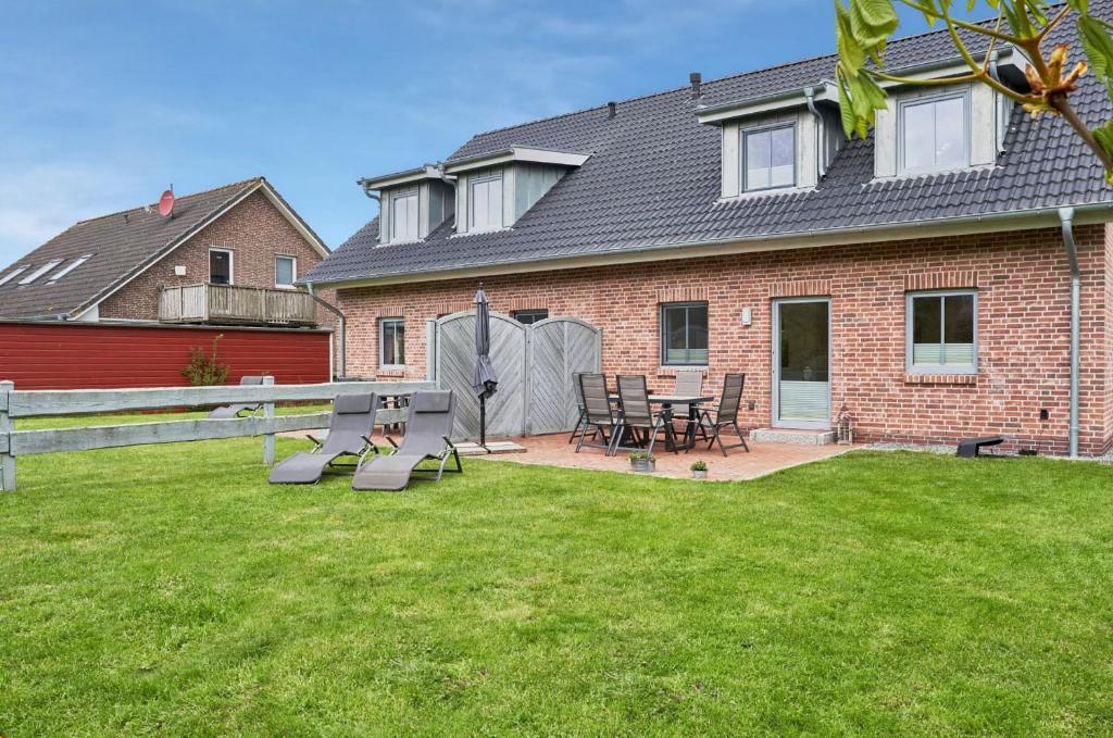 a house with a table and chairs in a yard at Deichläufer in Ockholm