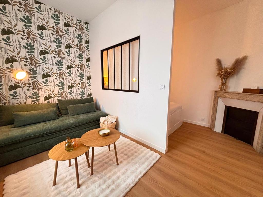 a living room with a green couch and a table at Le Tinqueux Chic-Studio rénové proche centre reims in Reims