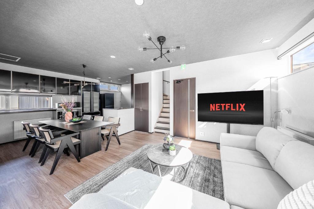 a living room with a white couch and a kitchen at Hoshiyado Nagayama in Asahikawa