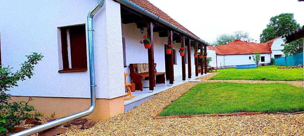a house with a hose attached to the side of it at Vándor Kakas Vendégház dézsafürdővel in Recsk