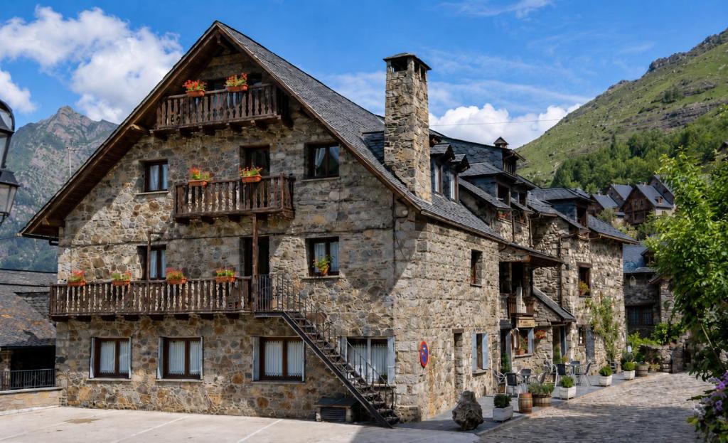 a large stone building with flowers on the balconies at Hostal Rural Sant Climent - Habitacions i Apartaments in Taüll