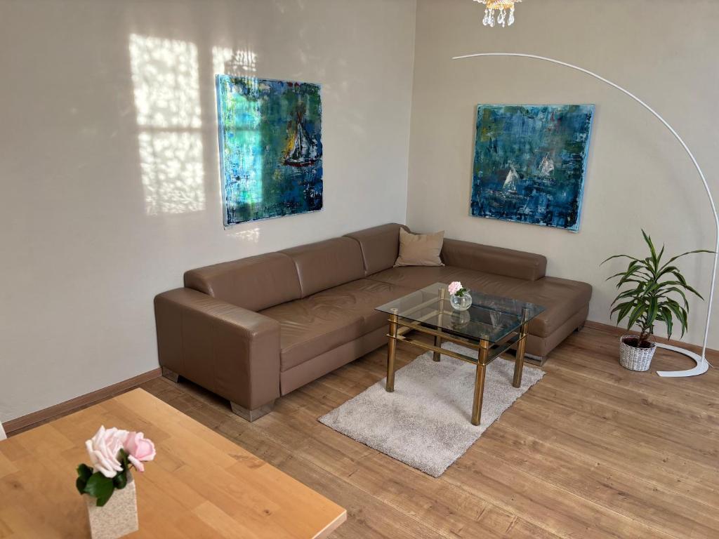 a living room with a brown couch and a table at Rosenwohnung in Neustrelitz
