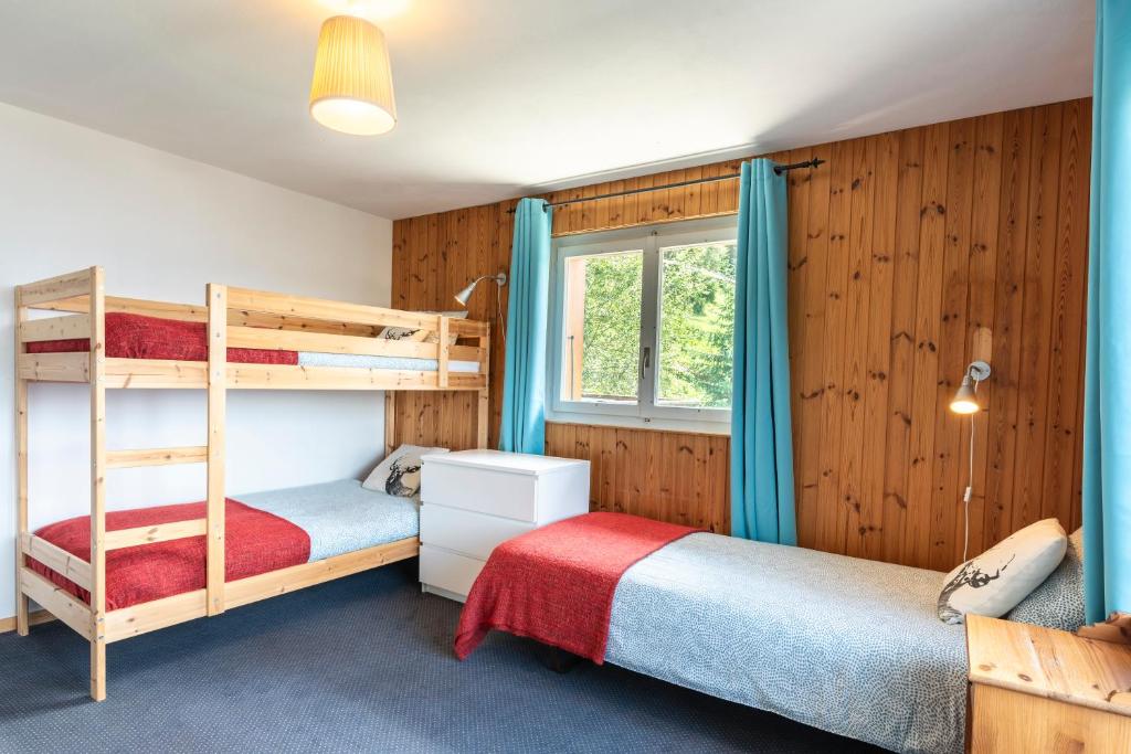 a bedroom with two bunk beds and a window at Mont Gele Hotel in Verbier