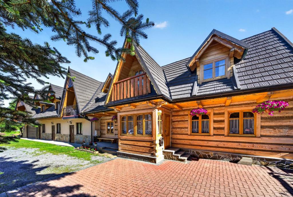 a log home with a gambrel roof at Domek u Świerków - apartamenty z aneksami i pokoje z mini lodówką blisko Term Chocholowskich in Chochołów