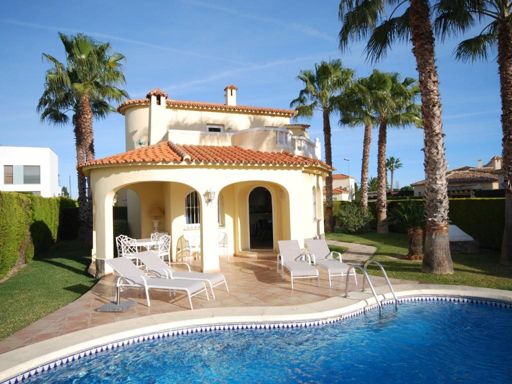 a villa with a swimming pool and palm trees at Charming Villa in Oliva with Private Swimming Pool in Oliva