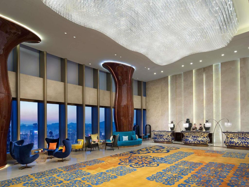 a lobby with a large room with chairs and tables at Sofitel Guiyang Hunter in Guiyang