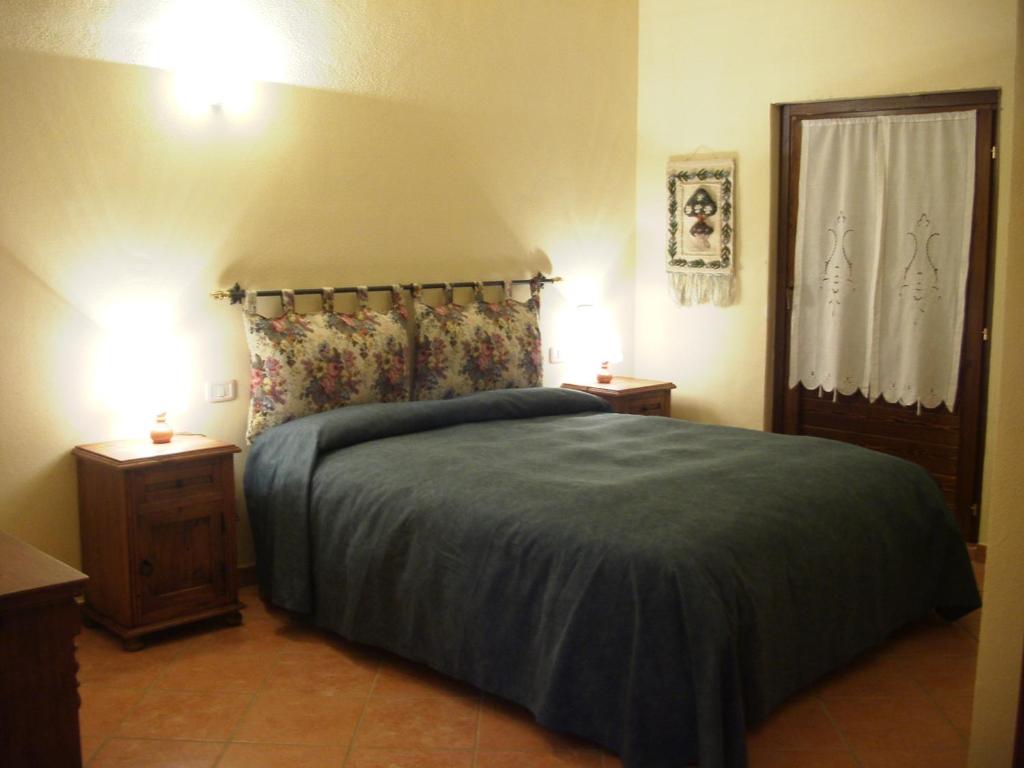 a bedroom with a bed with two night stands and two lamps at Agriturismo Radicata in Capalbio