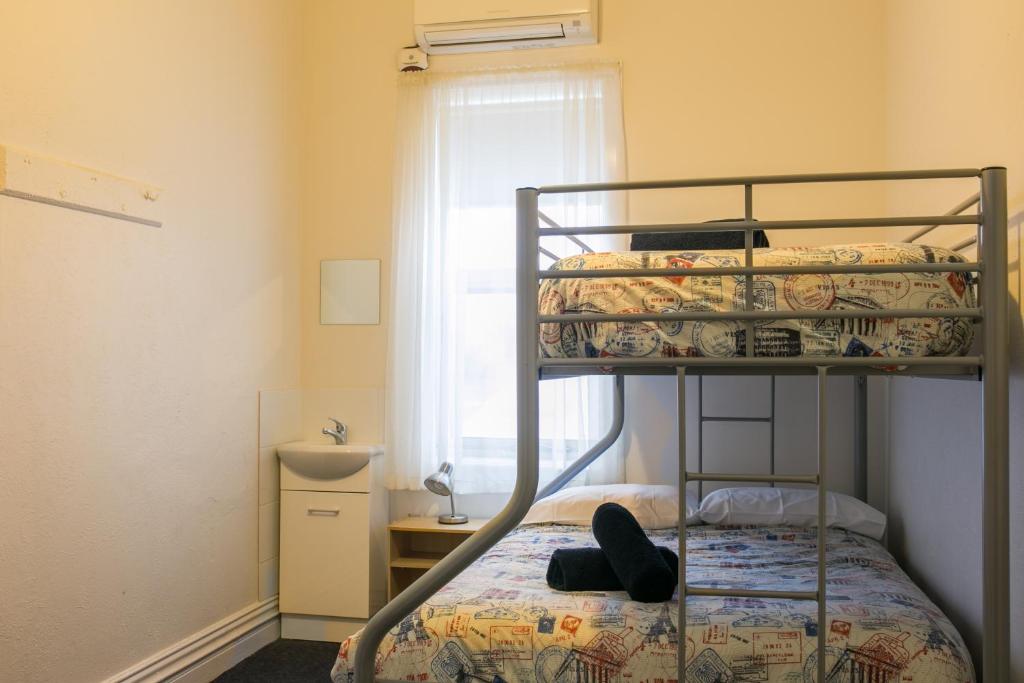 a bedroom with a bunk bed and a window at The Cally Hotel in Warrnambool