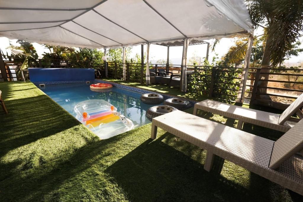 a swimming pool in a yard with a bench at Iinfinity home in Had Nes