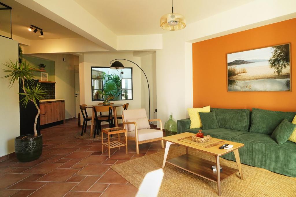 a living room with a green couch and a table at Cotto Apartment in Agios Nikolaos
