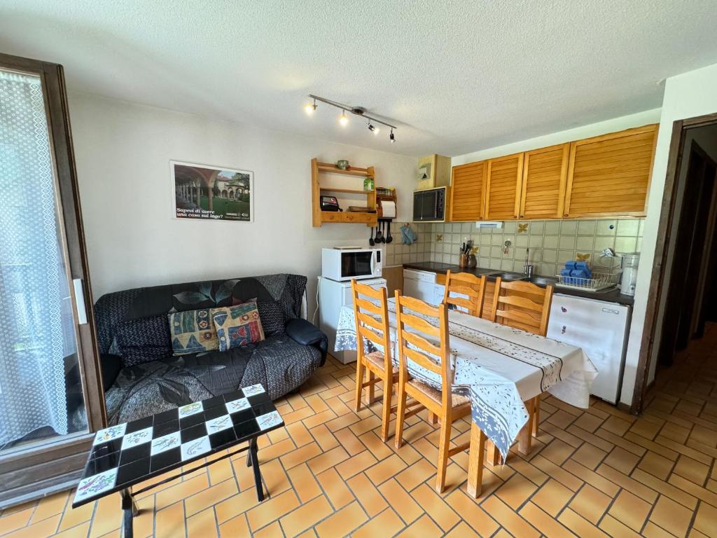 a kitchen and a living room with a table and a couch at Les Crêtes studio divisible by Mountain Collection Immobilier in Le Monêtier-les-Bains