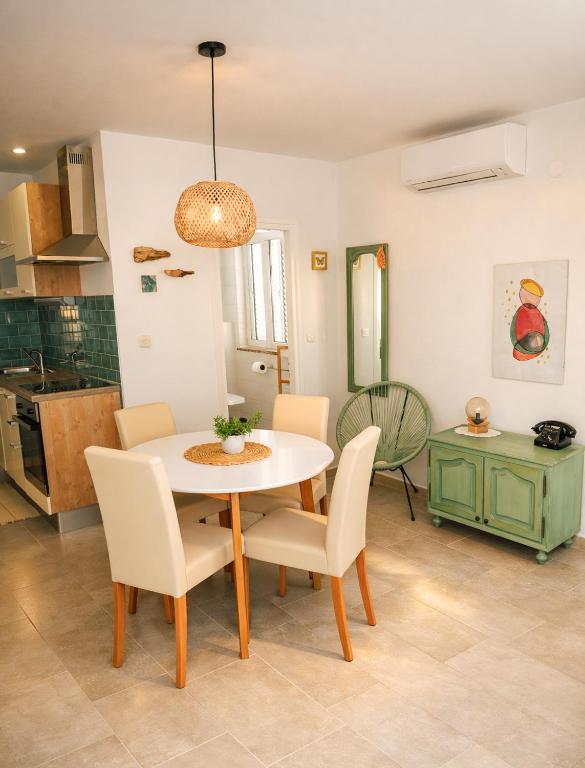 a kitchen and dining room with a table and chairs at Rab Pandelo Apartmani in Rab