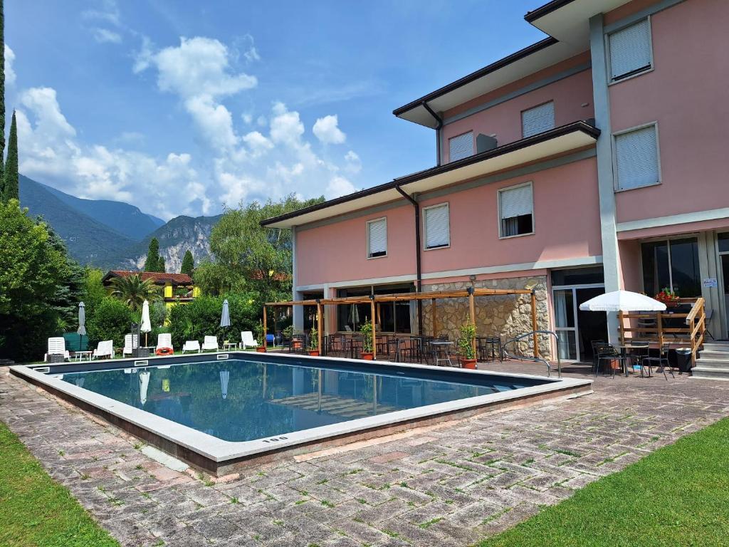 a house with a swimming pool in front of it at Hotel Diana in Riva del Garda