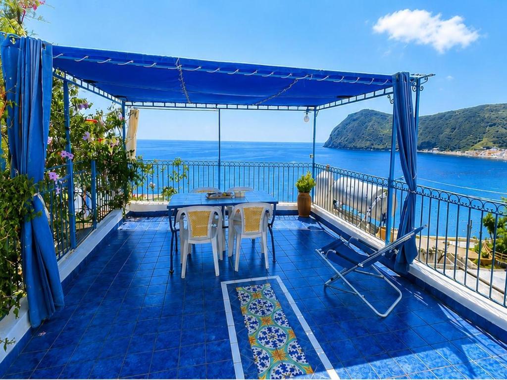 a balcony with a table and chairs and the ocean at Holiday Home Case Blu in Lipari