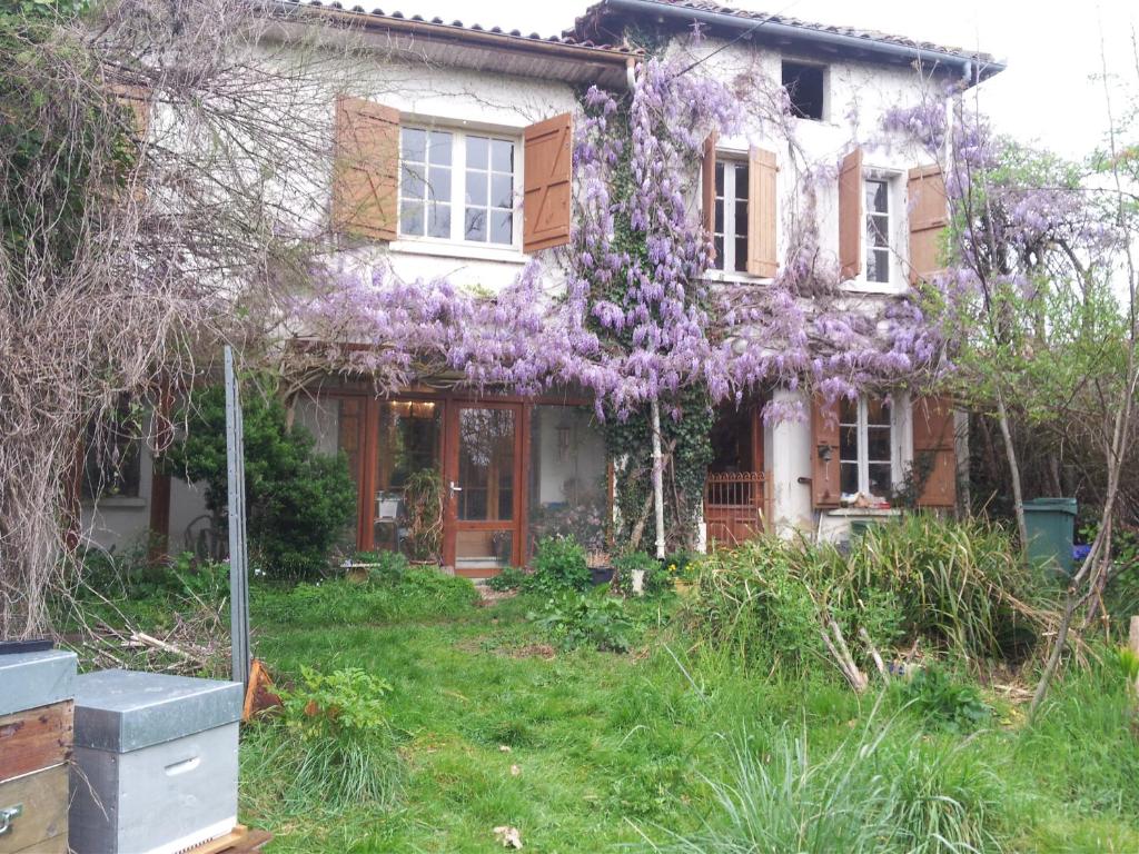 een huis met paarse bloemen erop bij l'estanquet in Eauze