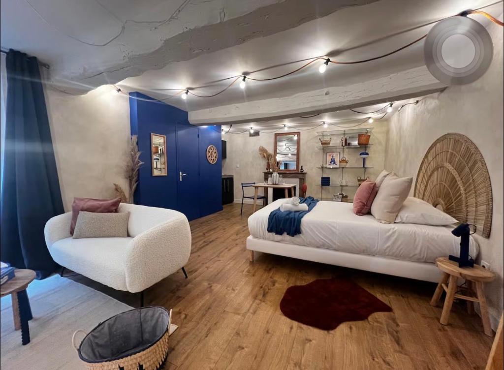 a bedroom with a large bed and a chair at Le Petit Horloge, Hyper centre de Rennes in Rennes