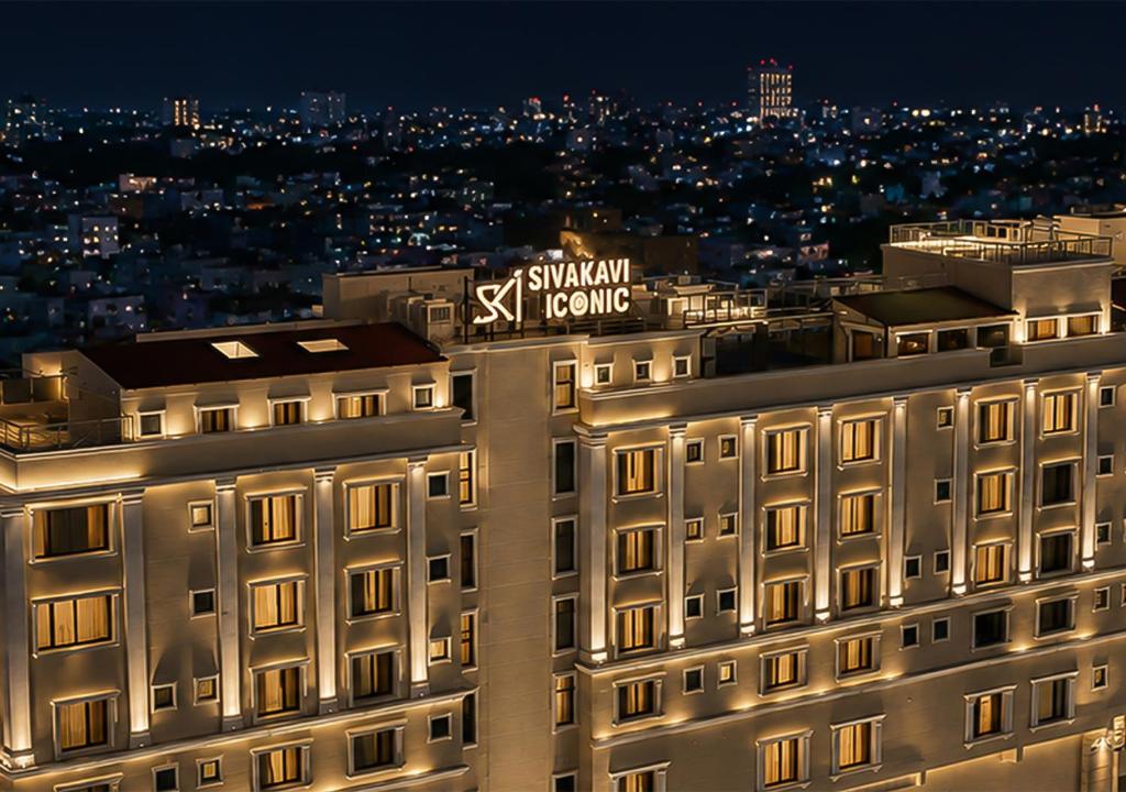 a building with a sign on top of it at night at SKI - Sivakavi Iconic in Pondicherry