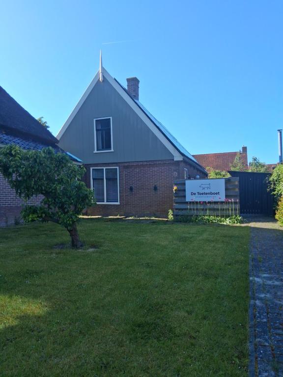 a house with a tree in the yard at Vakantiewoning De "Toetenboet" in Hem