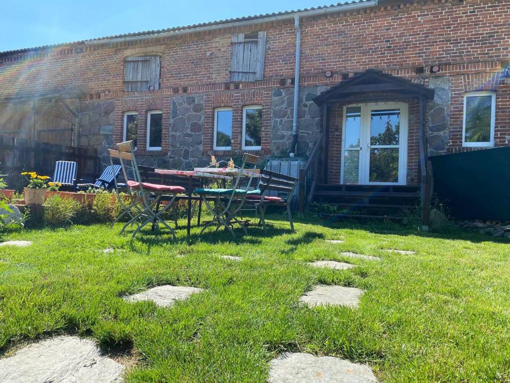 a yard with a table and chairs in front of a brick building at Ferienhof Uckermark am Oberuckersee in Suckow
