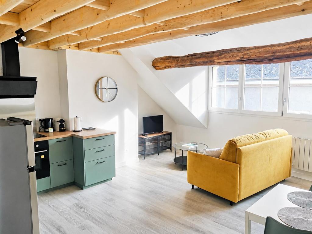 a kitchen and living room with a couch and a table at Duplex de charme au coeur de Beaugency in Beaugency