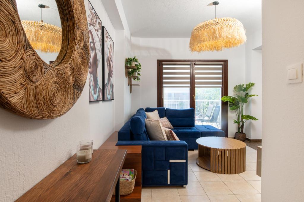 a living room with a blue couch and a table at Kallisti Luxury Rooms in Ierissos