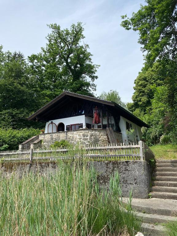 a small house with a fence next to some stairs at Seehaus Simssee in Stephanskirchen