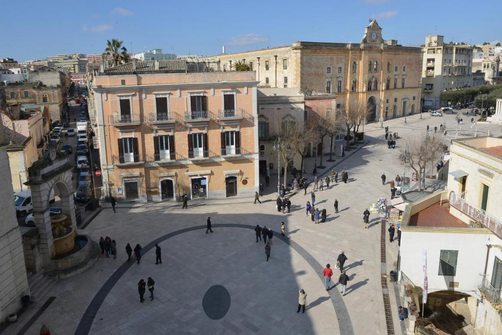 a group of people walking around a plaza in a city at Vittorio Veneto Matera Luxury Rooms in Matera
