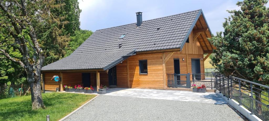 a wooden cabin with a driveway leading to it at Chalet avec jacuzzi privé, 3 chambres in Traubach-le-Haut
