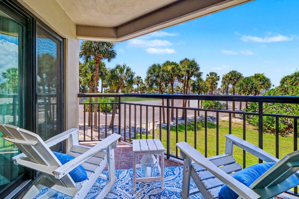 a porch with chairs and a balcony with a view at Gulf Strand Resort 207 in St. Pete Beach