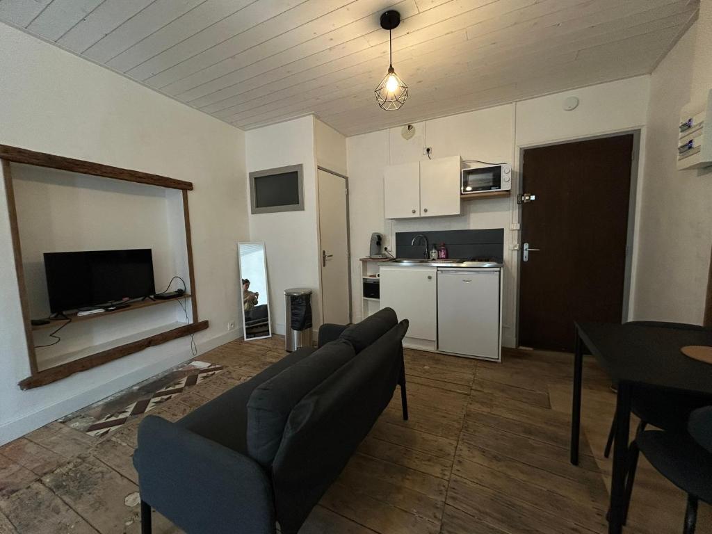 a living room with a couch and a kitchen at Studios Citadelle in Parthenay