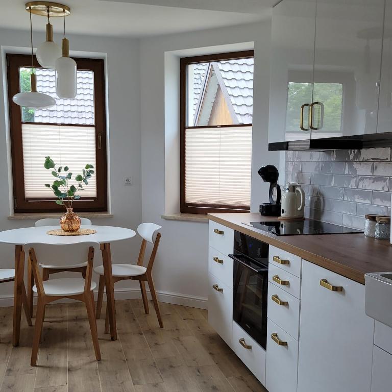 a kitchen with a table and a table and chairs at Start na Szlak - dom Rytro in Rytro