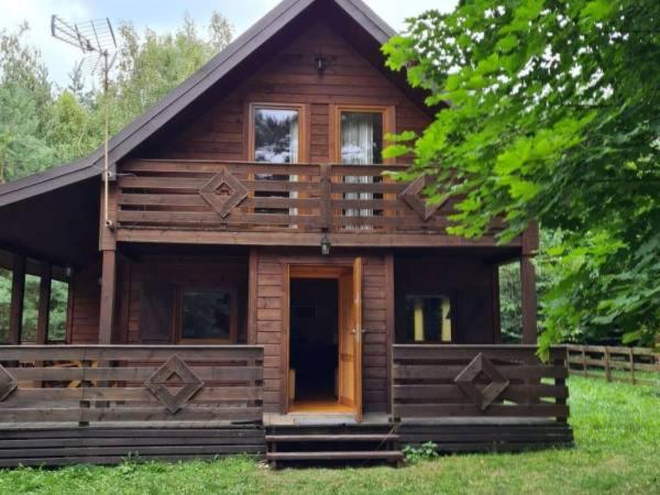a log cabin with a porch and a door at Leśna Arkadia in Dominice