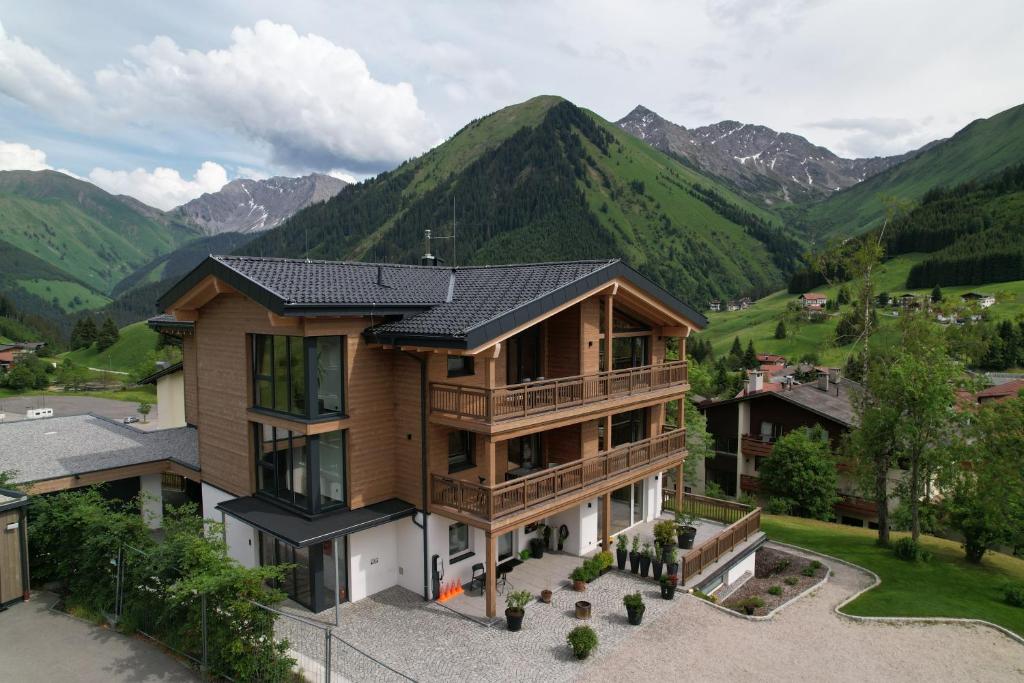 an aerial view of a house with mountains in the background at Berwang Chalets - Enzian in Berwang
