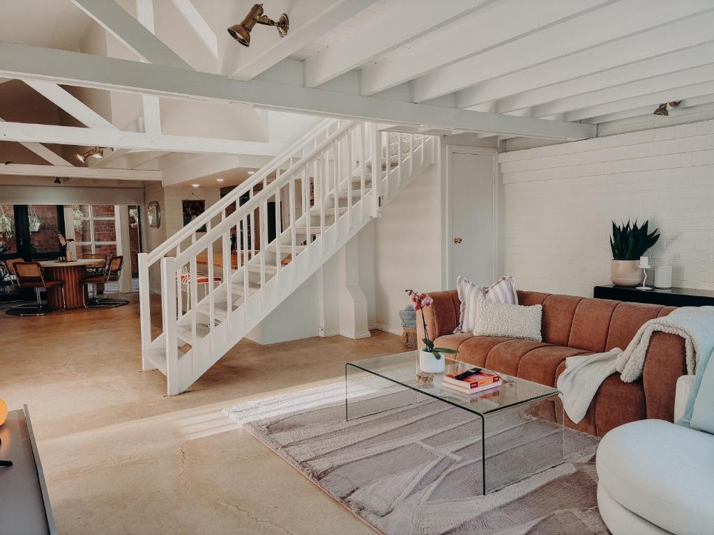 a living room with a couch and a staircase at Slow Haus Tanunda in Tanunda