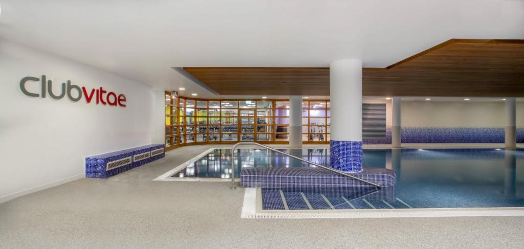 a swimming pool in a building with a library at Clayton Hotel Cardiff Lane in Dublin