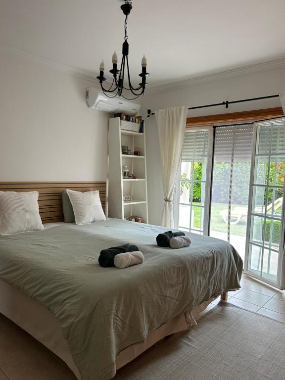 a bedroom with a large bed with two towels on it at Conjó - Golf & Beach Apartment Praia del Rey in Amoreira