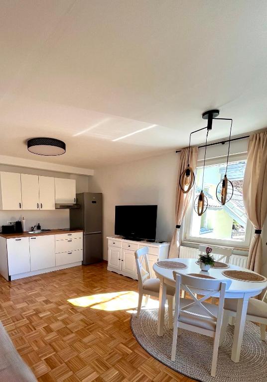 a living room with a table and a kitchen at Oaza Narave Apartment, Peaceful Retreat near Bled & Vintgar in Spodnje Gorje