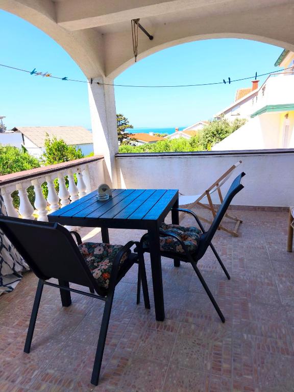 a blue table and two chairs on a balcony at Studio Stela 3 in Povljana