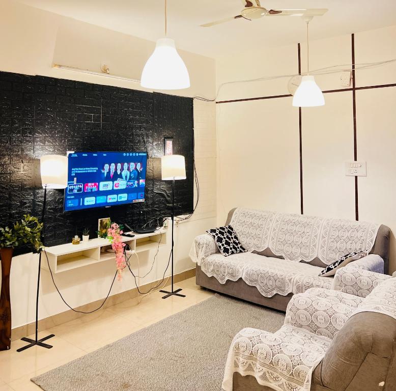 a living room with a couch and a tv at Electrifying Pearl in Bangalore