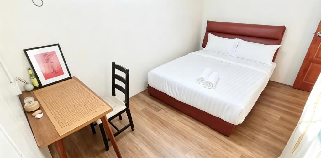 a small bedroom with a bed and a desk at Nangyang lodge in Malacca